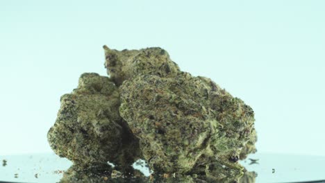 Nahaufnahme-Einer-Marihuana-Sativa-Super-Zitronen-Amnesie-Haze-Felsblumen,-Gelber,-Grüner-Und-Violetter-Kush,-Auf-Einem-Reflektierenden-360-Grad-Drehständer,-4k-Video-In-Zeitlupe