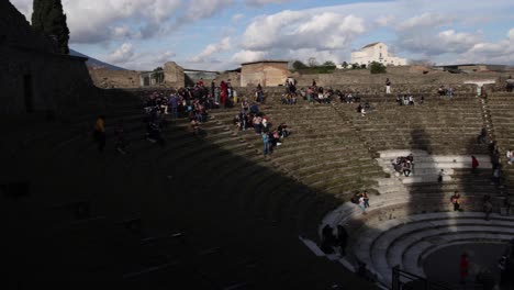 Antigua-Pompeya,-Anfiteatro-De-Italia-Con-Gente-Explorando-Y-Panoramización-De-Video-De-Derecha-A-Izquierda