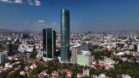 Aerial-view-approaching-the-torre-Mitikah-complex,-in-sunny-Benito-Juarez,-Mexico