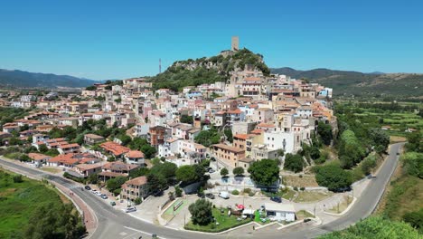 Posada-Village-and-Tower-on-Top-of-a-Hill-at-Sardinia,-Italy---Aerial-4k-Pedestal-up