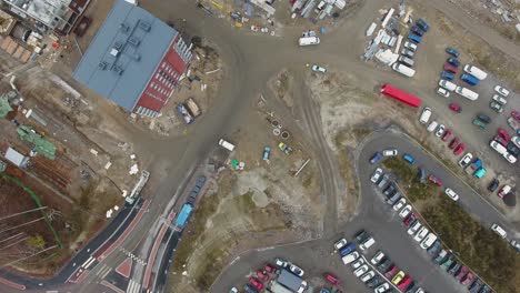 Top-down-aerial-view-of-a-construction-site-with-cranes-and-unfinished-buildings