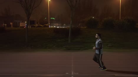 Tracking-shot-of-athletic-man-Jogging-at-night-time-in-Salamanca-city,-Spain