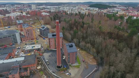 A-drone-shot-of-a-factory-chimney-standing-out-among-newly-built-homes