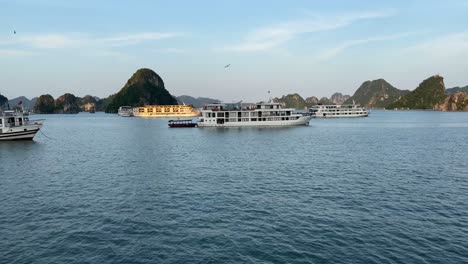 Halong-Bay-Vietnam,-moving-towards-Junk-boats-anchored-in-calm-water