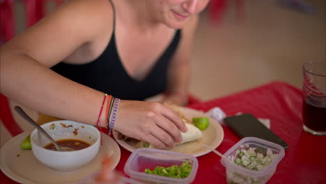 Zeitlupe,-Nahaufnahme-Einer-Lateinamerikanischen-Frau,-Die-In-Einem-Restaurant-In-Mexiko-Einen-Barbacoa-Taco-Isst