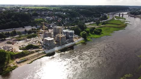Construction-site-of-river-coast-apartment-building-complex,-aerial-drone-view