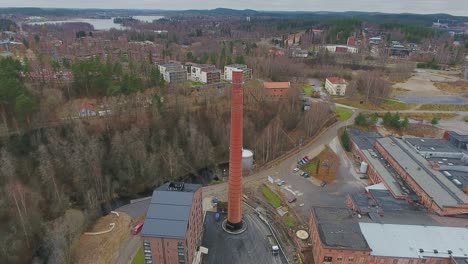Aerial-shot-of-an-old-factory-chimney-in-middle-of-a-newly-built-residential-district