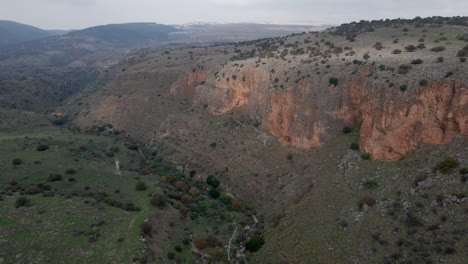 Drone-orbiting-view-above-valley-in-Israel-with-steep-cliffs-and-rocky-terrain