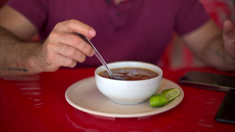 Slow-motion-close-up-of-a-latin-man-stirring-his-barbacoa-broth-with-a-spoon-in-a-restaurant-in-Mexico