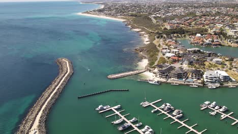 Aerial-footage-of-flying-over-Mindarie-Marine-and-the-pier-and-boats-on-a-clear-summers-day