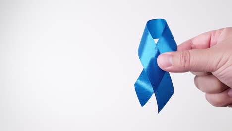 Detail-of-male-hand-holding-ribbon-in-Light-blue-color-on-white-background