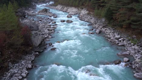 Una-Vista-De-ángulo-Alto-De-Un-Río-Que-Fluye-Con-Agua-Glacial-En-Las-Montañas-Del-Himalaya-De-Nepal