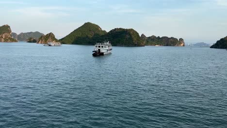Panning-behind-Junk-boats-in-the-calm-ocean-in-scenic-Halong-bay,-Vietnam