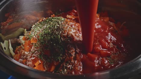 Tomato-Juice-And-Soy-Sauce-Being-Poured-Over-Heap-Of-Herbs-In-Vegetable-Pot-Stew