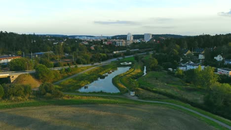 Drone-shot-of-pound,-field-and-railway-in-Upplads-Väsby,-Stockholm,-Sweden