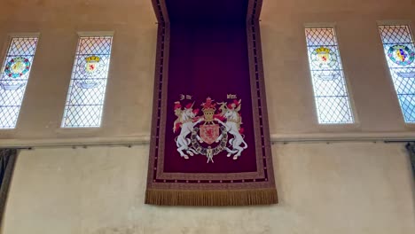 Panning-shot-of-red-decorative-material-with-the-royalty-crest-inside-Stirling-Castle
