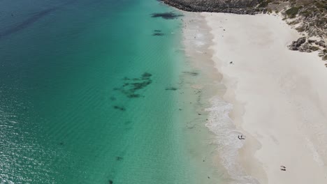 Aerial-drone-view-of-clear-ocean-and-white-sand-on-a-summers-days-at-Mindarie-Beach-in-Western-Australia