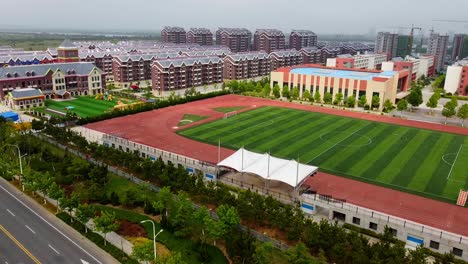 Vista-Aérea-De-Un-Campo-De-Fútbol-En-El-Moderno-Complejo-Urbanizado-Del-Nuevo-Distrito-De-Nanhai,-China