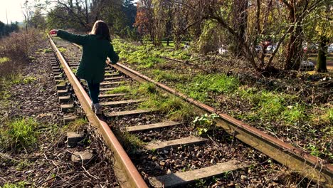 young-girl-walking-on-a-single-rail-track-towards-the-infinite
