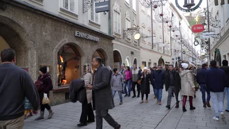 Turistas-Paseando-Por-La-Calle-De-Navidad-En-Salzburgo,-Austria