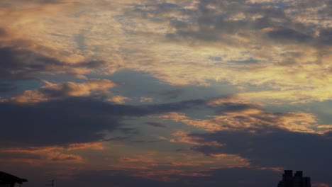 A-colorful-amazing-sunset-surfing-clouds,-blue-and-yellow,-orange-sky,-time-lapse,-4K-video