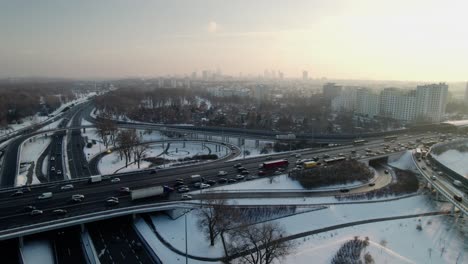 Abfangen-Von-Lufteinrichtungen-Mit-Autoverkehr-In-Warschau,-Hauptstadt-Polens,-Verschneite-Und-Vereiste-Straße,-Luftbild-Mit-Drohne