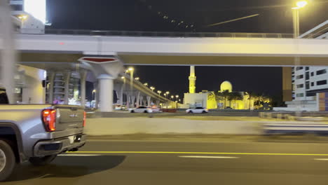 Camión-Gmc-Conduciendo-Por-La-Autopista-Del-Suburbio-De-Dubai-Por-La-Noche,-Vista-Lateral