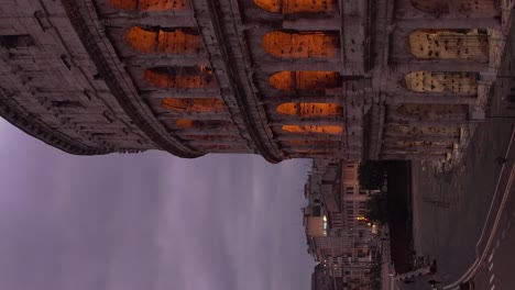 Famoso-Coliseo-De-Roma-Italia-En-La-Mañana-De-Noche-A-Día-Timelapse-En-La-Mañana-Con-Un-Cielo-Nublado-Y-Luces-Ambientales-Apagándose---Vertical