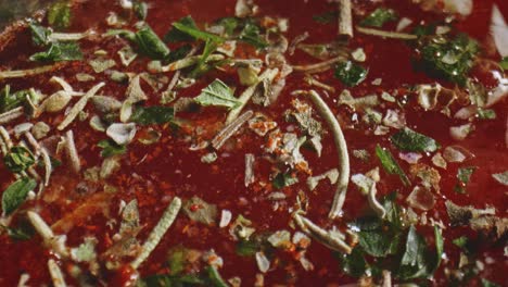 Extreme-Close-Up-of-Salt,-Paprika,-Garlic-Powder-And-Rosemary-Resting-On-Tomato-Vegetable-Stew-Sauce