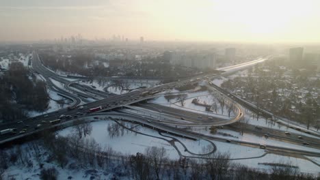 Panoramic-aerial-view-of-the-intersection-S8,-with-traffic-at-rush-hour-with-icy-road-covered-of-snow-in-the-city-of-Warsaw,-Poland