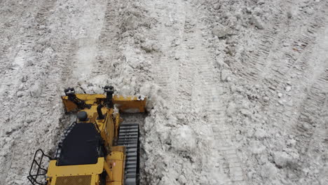 snowplow-pile-up-mountains-of-snow-after-devastating-historic-Buffalo-Blizzard,-tracking-shot