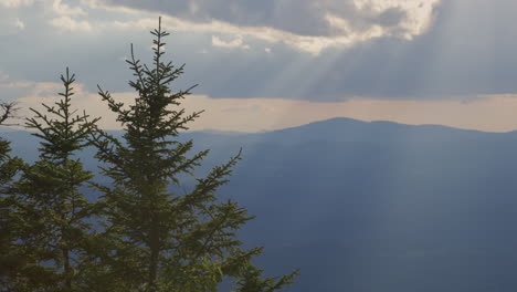 A-mountain-top-landscape-view-at-sunset-with-god-rays-of-light-coming-down-in-Vermont