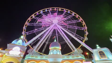 Ferris-wheel-with-video-projection-at-the-entrance-of-the-adventure-park-at-Global-village-theme-park-seen-at-night