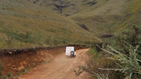 Robust-tour-company-vehicle-drives-dirt-road-in-Sani-Pass-to-Lesotho