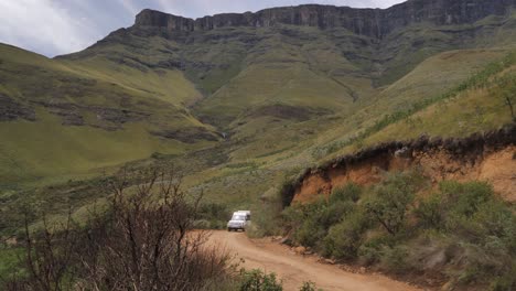 Sturdy-tour-truck-drives-up-rugged-gravel-road-to-Sani-Pass,-Lesotho