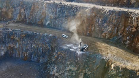 An-Aerial-View-of-a-Track-mounted-drilling-rig-drilling-into-rock-to-create-holes-for-explosives-in-order-to-break-up-large-rocks-in-a-limestone-quarry-in-Germany