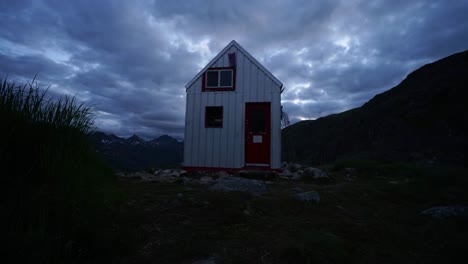 Time-lapse-of-an-outdoor-structure-in-the-Alaskan-brush-at-dusk-with-clouds-rolling-over-head