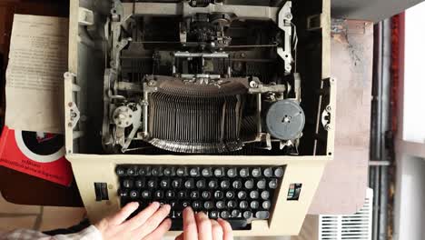 Vista-Aérea-De-Una-Persona-Escribiendo-En-Una-Máquina-De-Escribir-Manual-Antigua