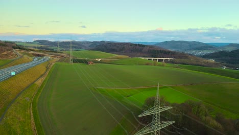 Aerial-View-of-Powerlines-Connecting-German-Power-Grid-with-the-Sauerland,-Germany-next-to-Autobahn-46