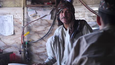 Panadero-Masculino-Hablando-Con-Un-Colega-En-La-Tienda-De-Pan-Tradicional-En-Quetta,-Pakistán