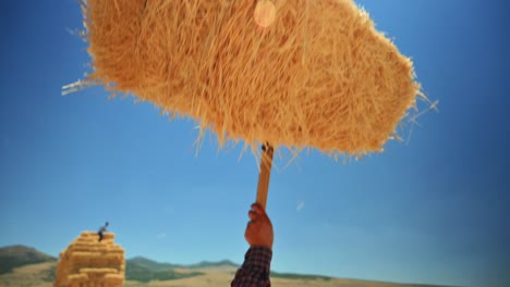 Holding-a-bale-of-straw-against-the-blue-sky