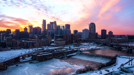 Aerial-hyperlapse-of-the-sun-setting-behind-Minneapolis-skyscrapers-with-St-Anthony-Falls-in-the-foreground