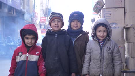 Grupo-De-Niños-Pequeños-Parados-En-La-Calle-Fuera-De-La-Tienda-En-Quetta,-Baluchistán