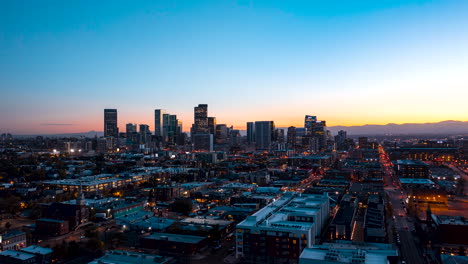 Aerial-hyperlapse-of-Denver,-Colorado-at-sunset-with-cars-commuting-home-on-the-lit-streets
