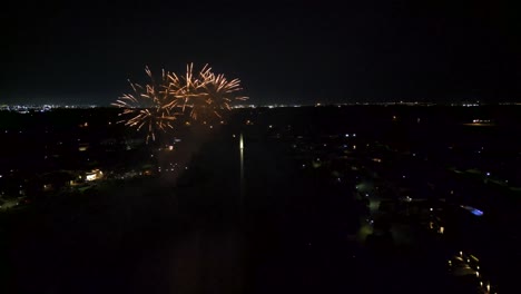 Fireworks-display-above-the-city-lake,-aerial-wide-view
