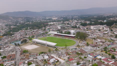 Wide-aerial-flyover-of-a-small-soccer-stadium-in-Huehuetenango,-Guatemala