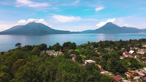 Aerial-Flyover-Village-Toward-Lake-and-Volcanoes---Lake-Atitlan,-Panajachel,-Guatemala