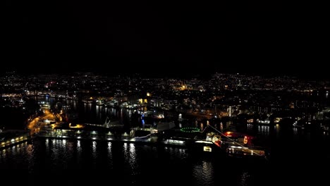 Smaller-private-fireworks-launched-throughout-the-city-of-Bergen-during-new-year-celebration---Aerial-from-the-harbor-and-city-fjord