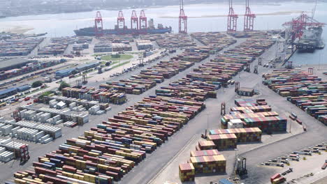 Wide-aerial-shot-of-the-shipping-containers-in-Durban-harbour-along-with-large-cargo-ships-being-loaded-by-gantry-cranes