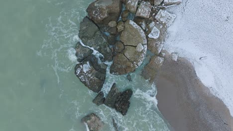 Aerial-birdseye-view-of-abandoned-seaside-fortification-buildings-at-Karosta-Northern-Forts-on-the-beach-of-Baltic-sea-,-overcast-winter-day,-drone-shot-moving-forward